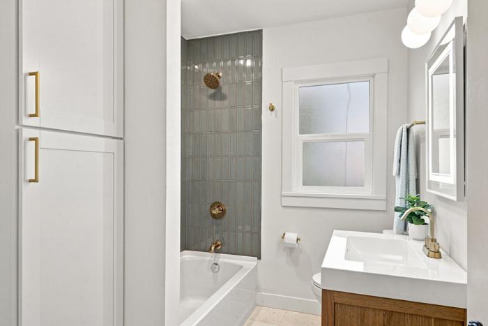 Hall bath storage. Built-in linen cabinet beside the tub