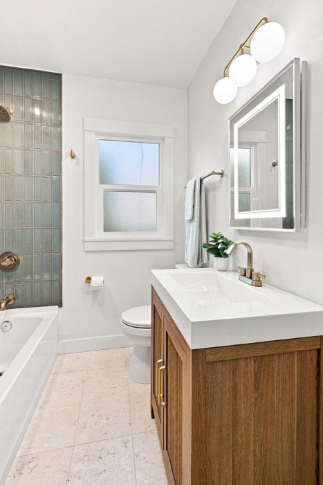 Hall bath. Vertical stack tile, warm wood vanity