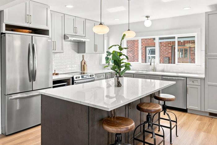 Kitchen with island seating. Shaker cabinets, quartz counters, two-tone island