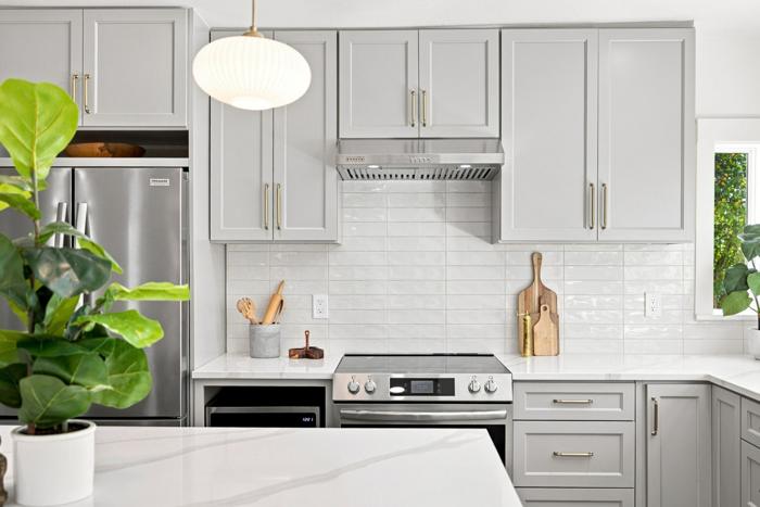 Range and hood detail. Brushed brass hardware, under-cabinet hood
